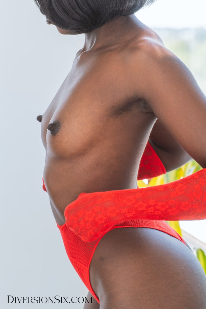A black woman with nice perky tits and errect nipples wearing red lingerie gloves